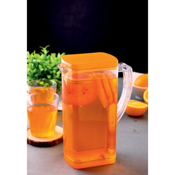 Transparent jug filled with orange juice with glasses